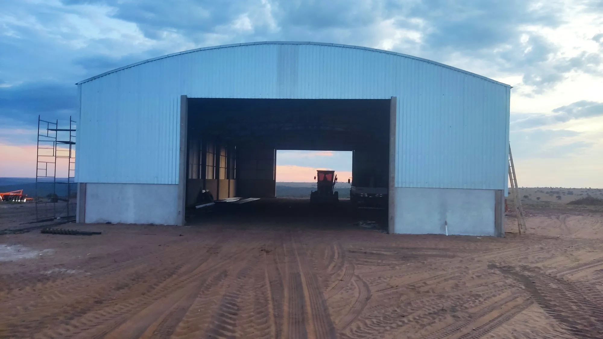 Galpão metálico pronto com portão aberto mostrando vão livre para máquinas agrícolas — Norte do Paraná